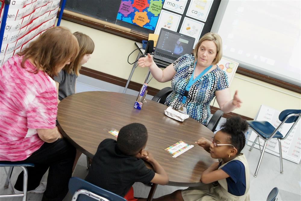 A teacher at Edgewood Learning Center, middle, instructs students before conducting an activity.