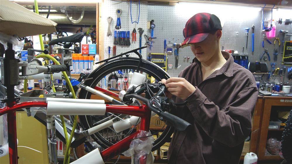 A Pathfinder School student works on a bicycle as part of a career development program.