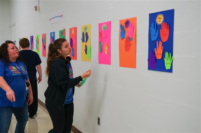 Students help Mr. Nick find the right placements on the wall using their hands!