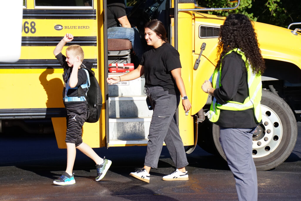 child stepping off the bus on the first day of school