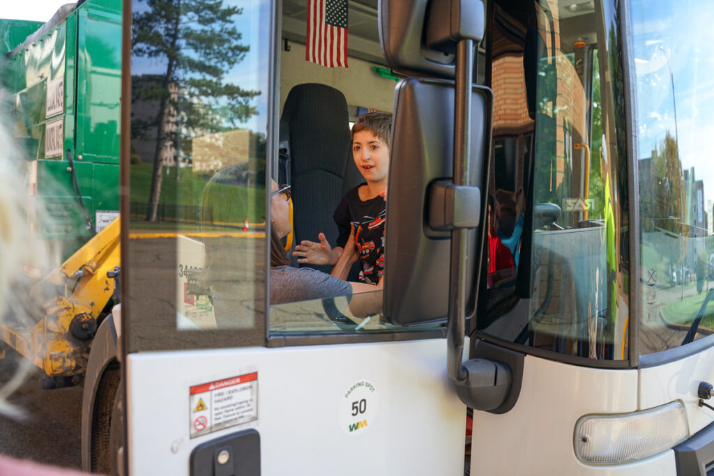 student sitting inside garbage truck