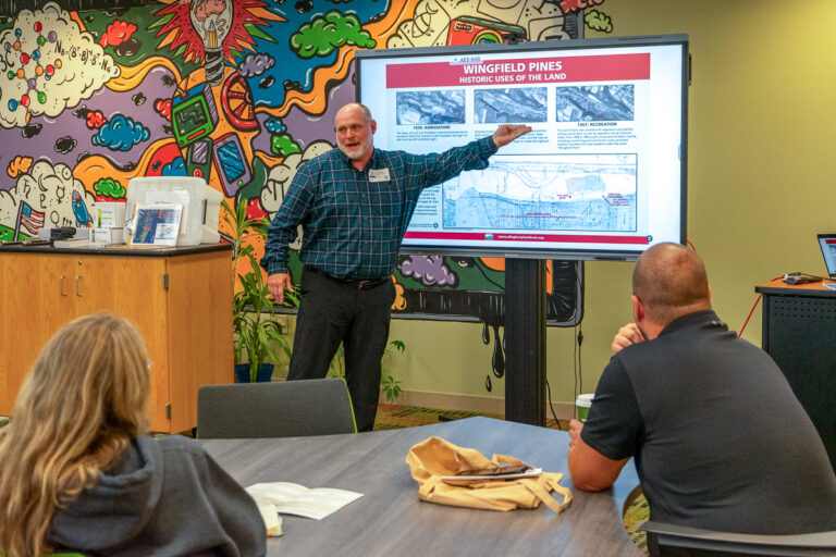 instructor standing in front of digital screen