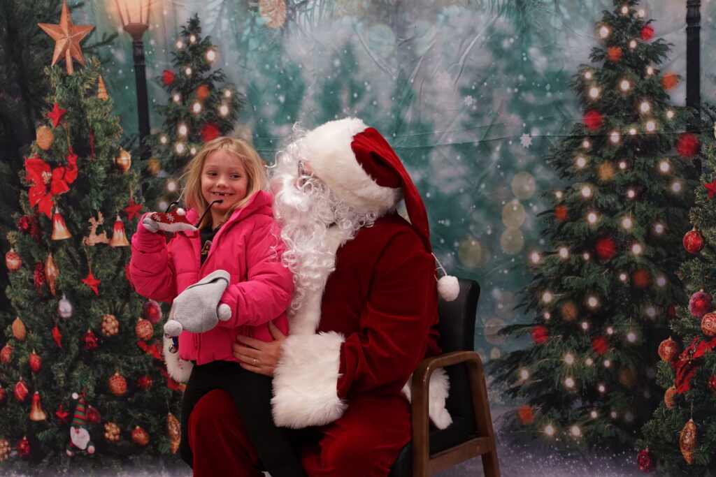 Photo of Santa Claus sitting in a chair with child on his lap
