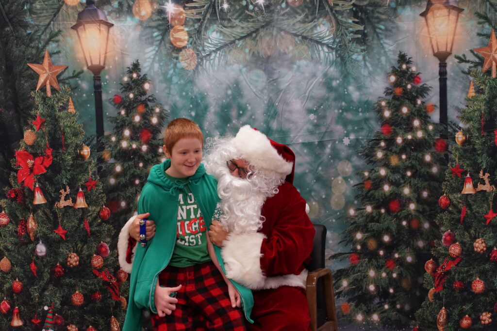 Photo of Santa Claus sitting in a chair with child on his lap