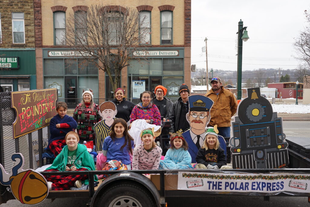 Photo of children and adults sitting in and around the trailer
