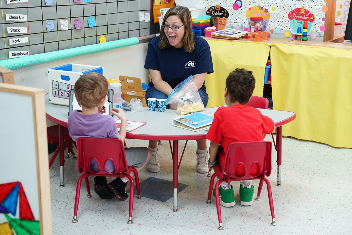 preschool teachers instructs students during snacktime