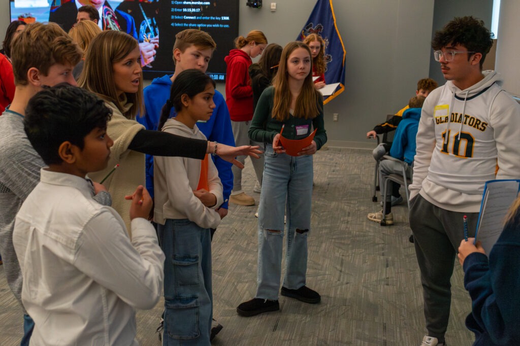 A teacher speaks with students in a small group.
