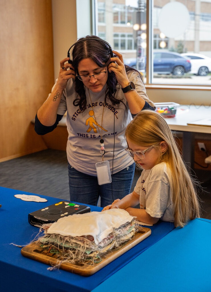 student and teacher interact with tactile display at library for accessible media