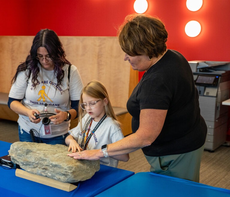 student and teacher interact with tactile display at library for accessible media