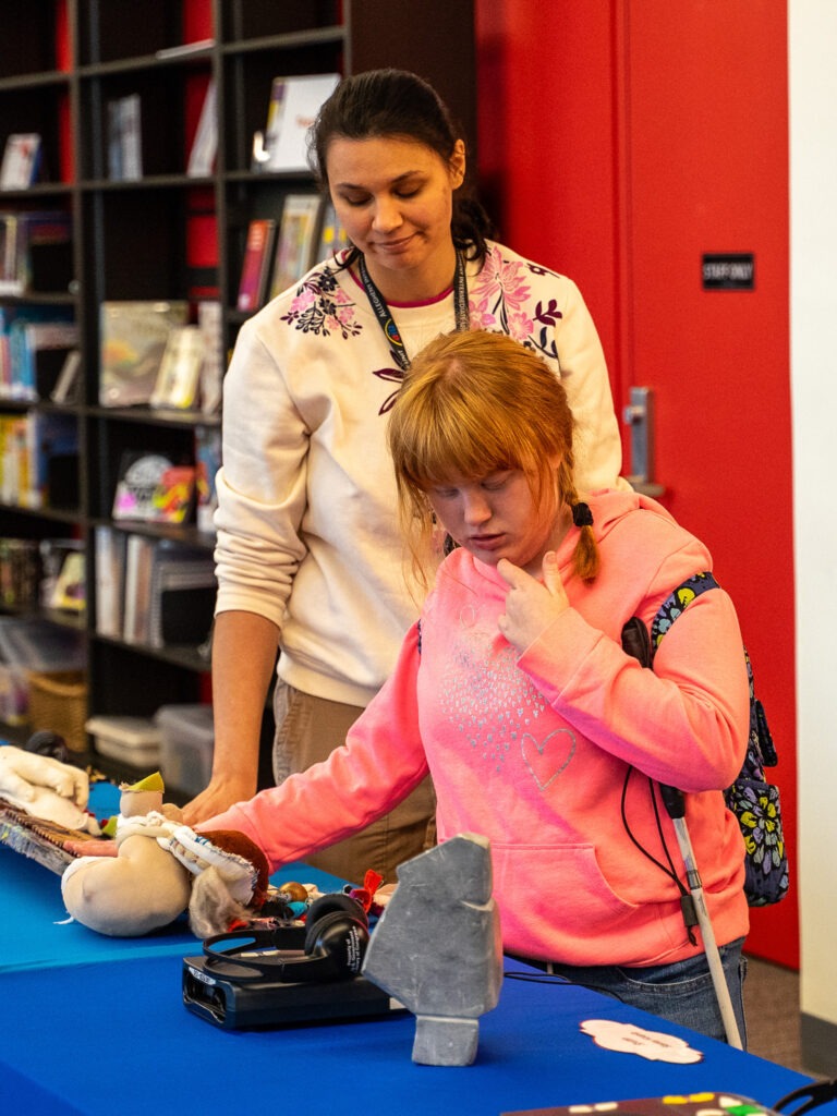 student and teacher interact with tactile display at library for accessible media