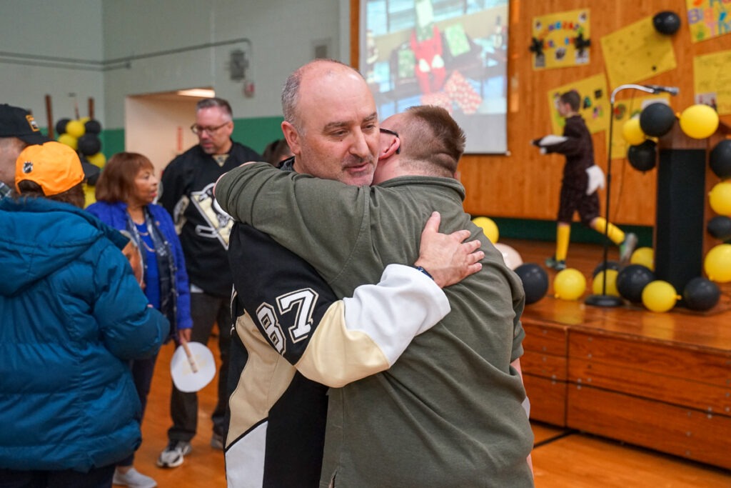 principal David Campos hugs a student