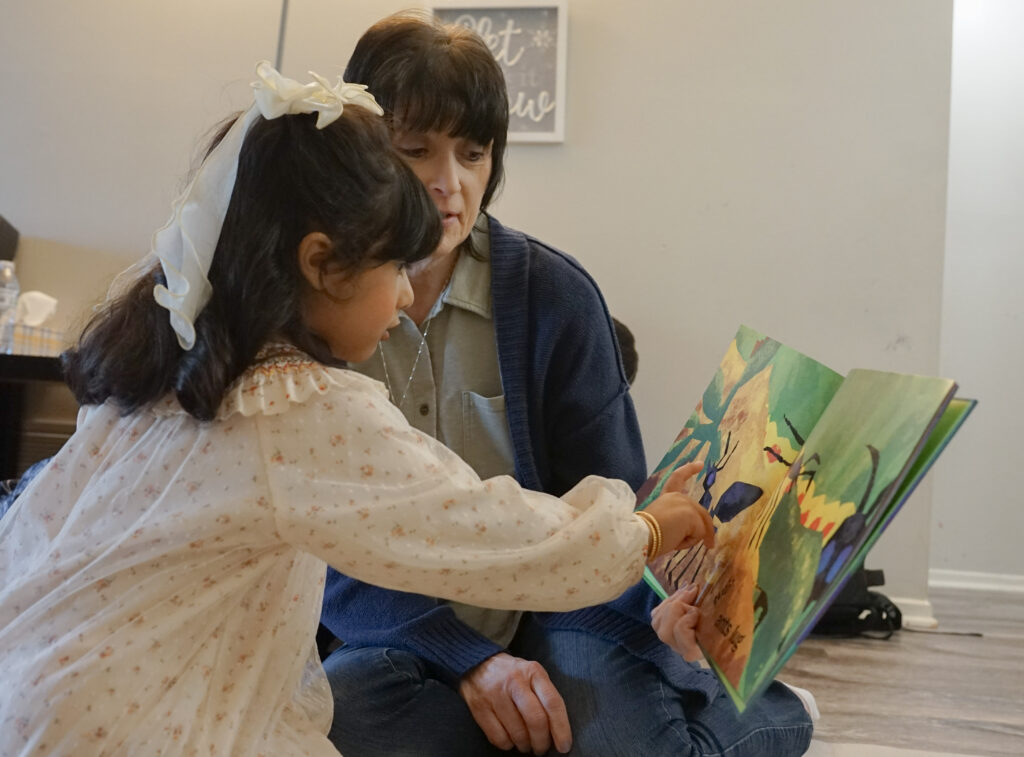 Michele Stillwagon reading a picture book to a Head Start student