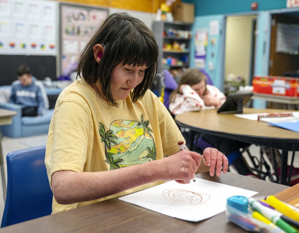 student with mobility challenges draws artwork