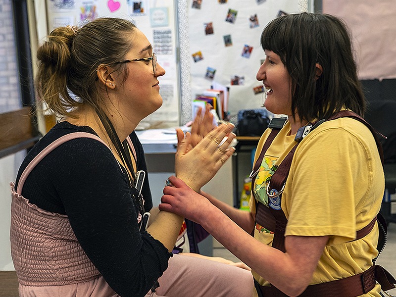 student interacts with teacher in classroom
