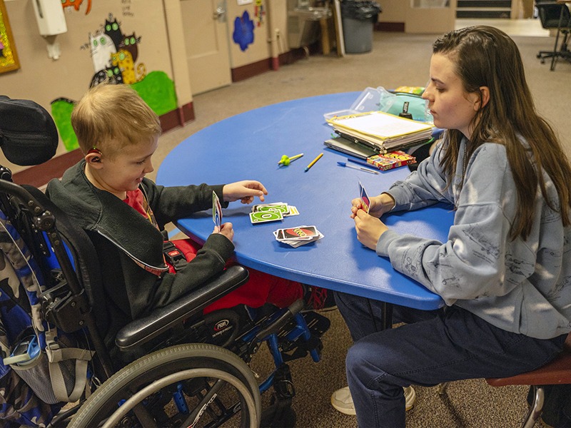 student in wheelchair works on activities with occupational therapist