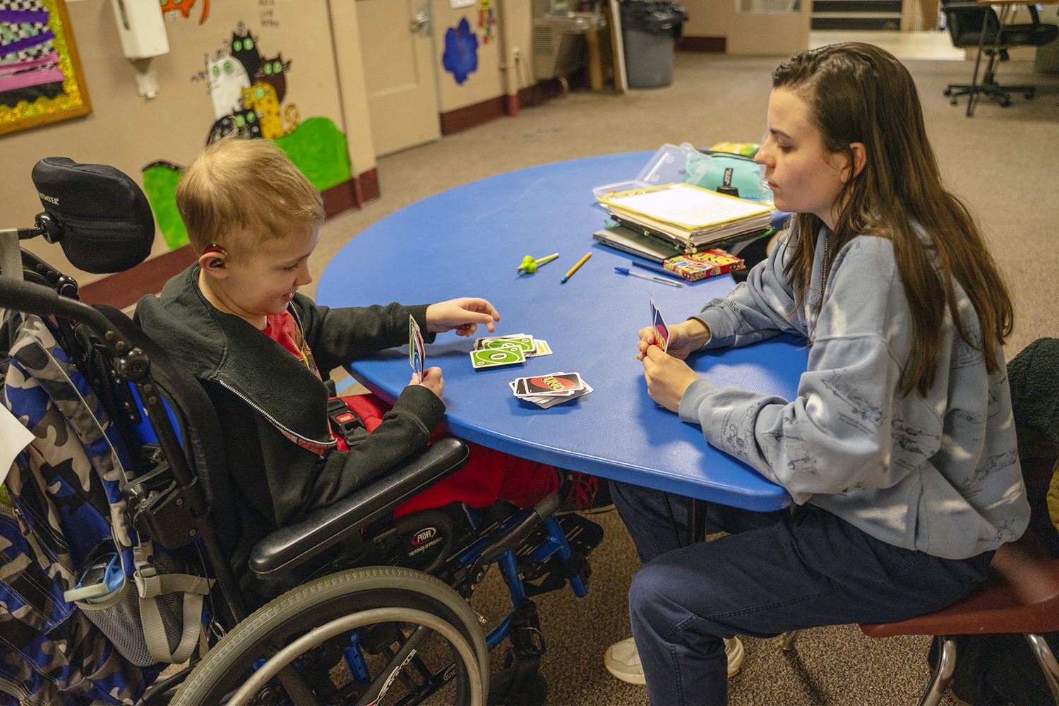 student plays cards with occupational therapist