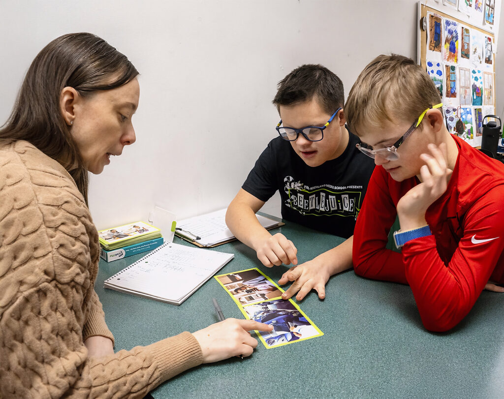 two students interact with speech language pathologist