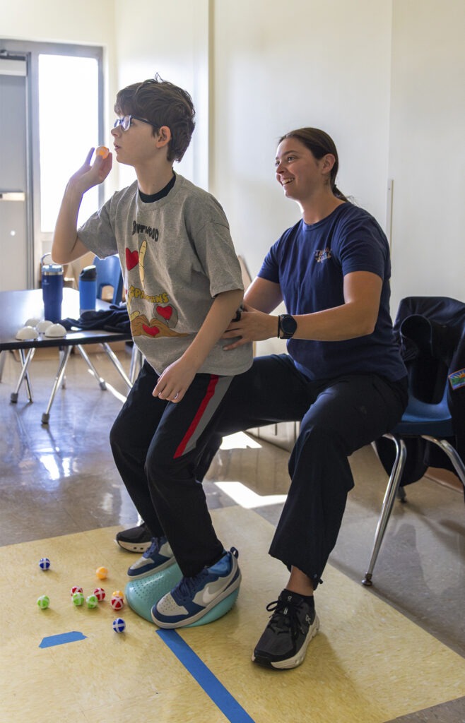 physical therapist works with student