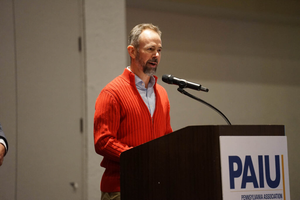 Dr. Robert Scherrer speaking in front of PAIU attendees