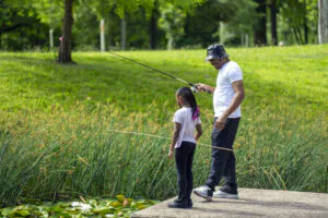 Father watching daughter fish