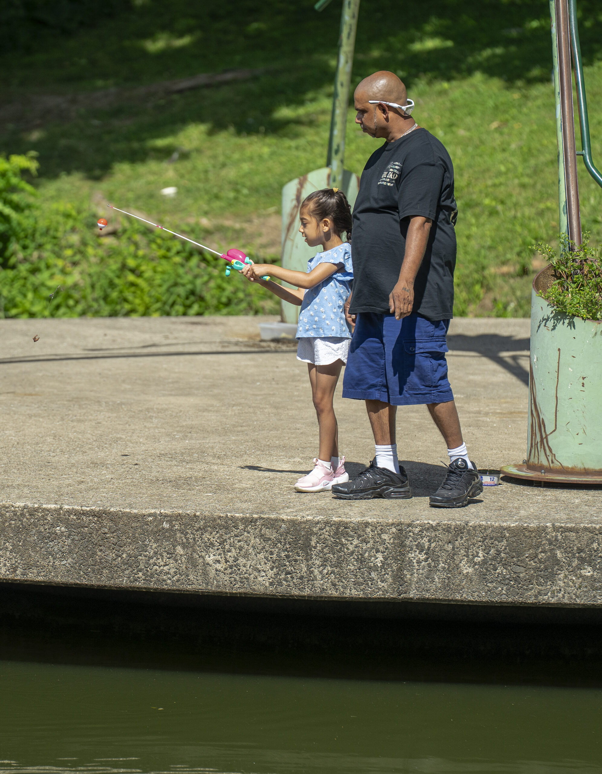 Dad helping daughter fish