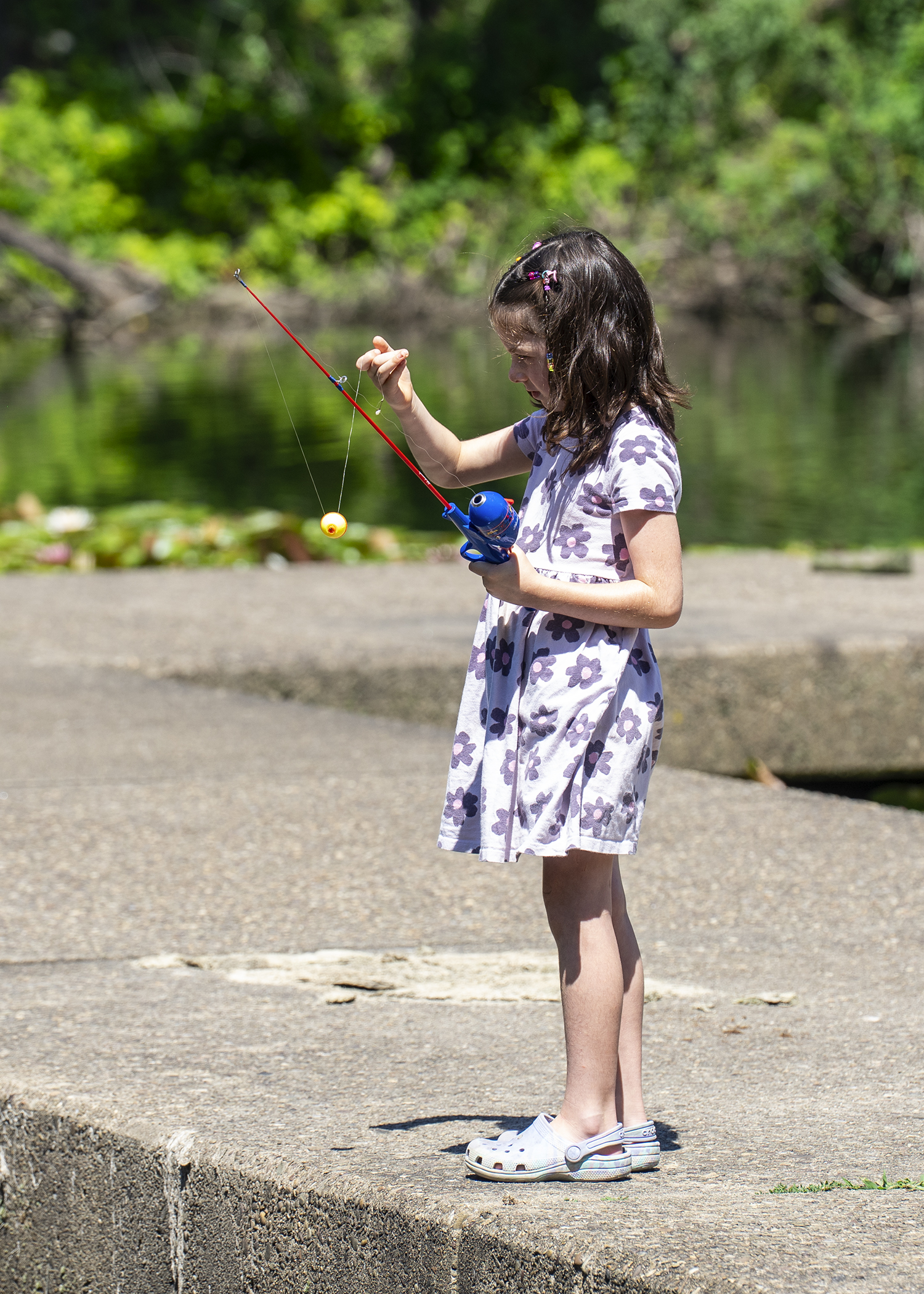 a girl at the lake untangling a fishing line