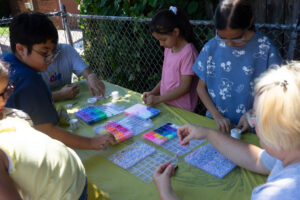 families and aiu staff making bracelets