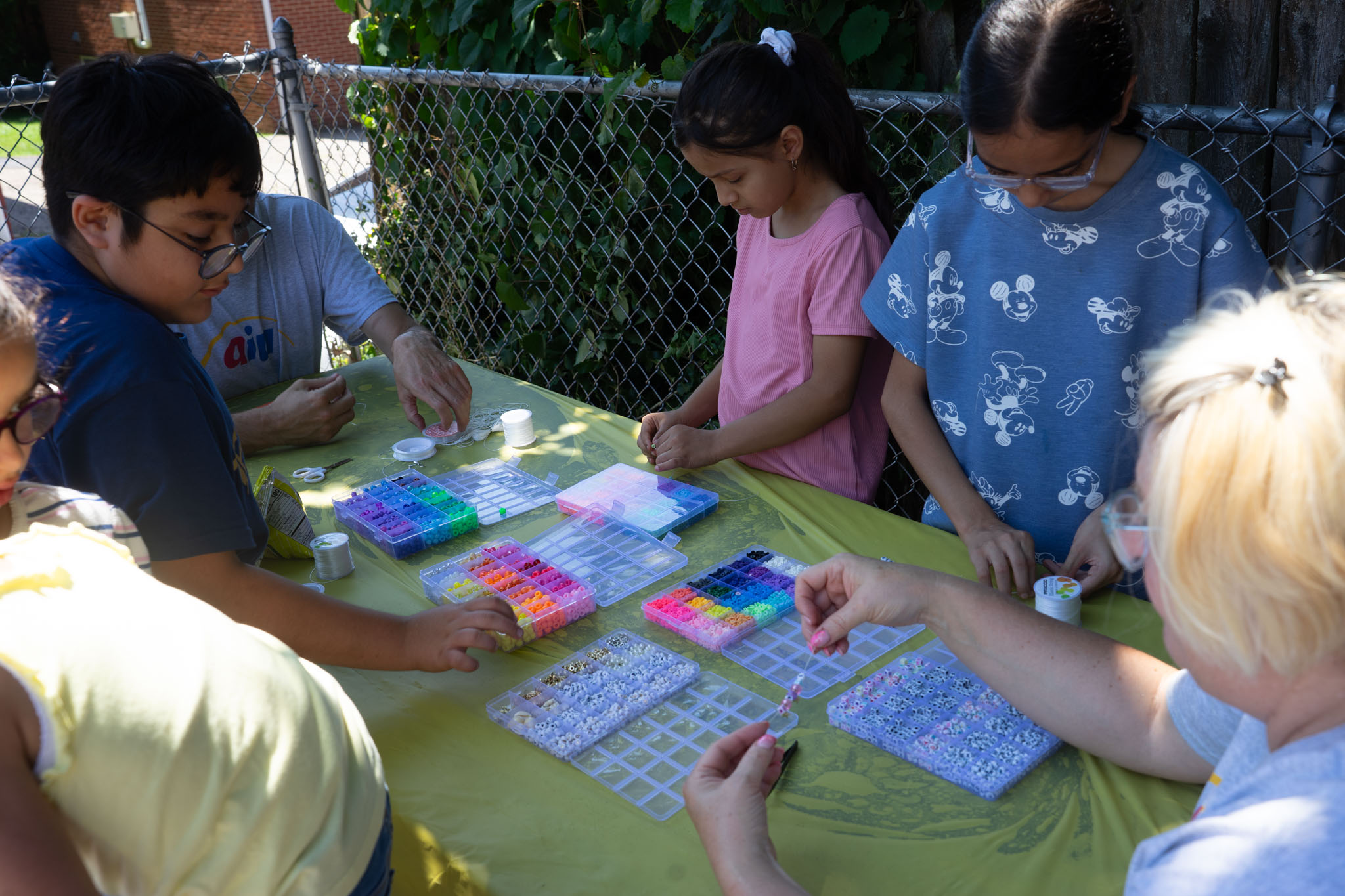 families and aiu staff making bracelets