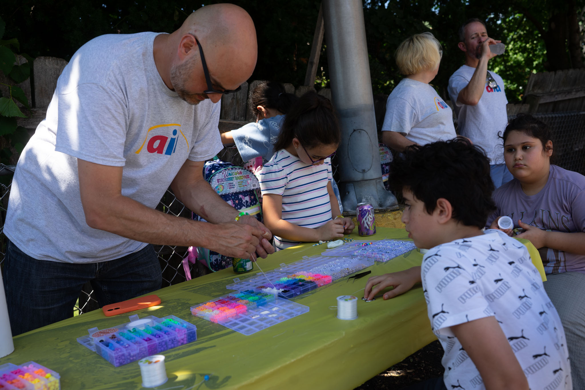 aiu staff helping kids with bracelets