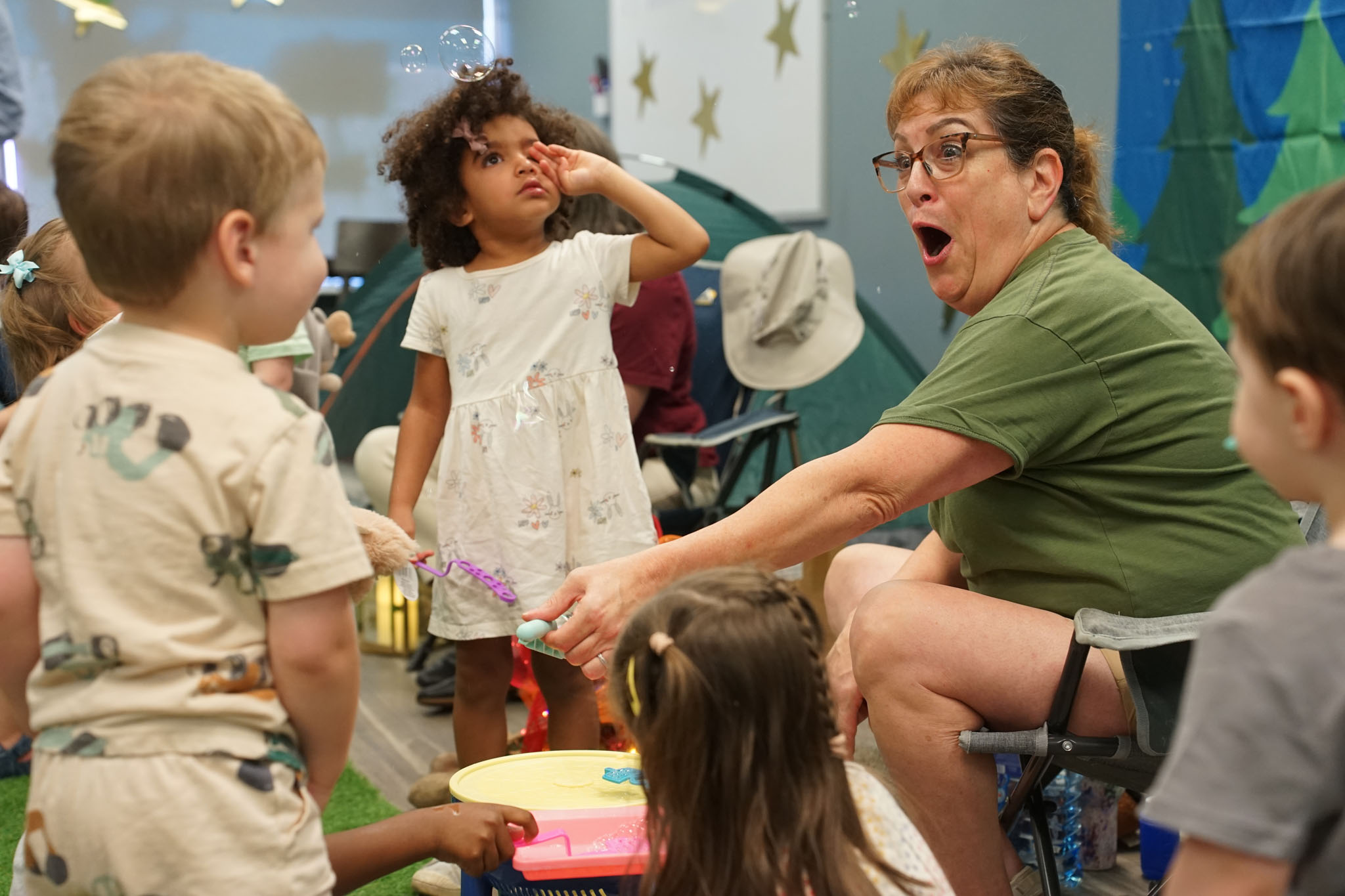 Ms. Robin showing children how to use the bubble wands