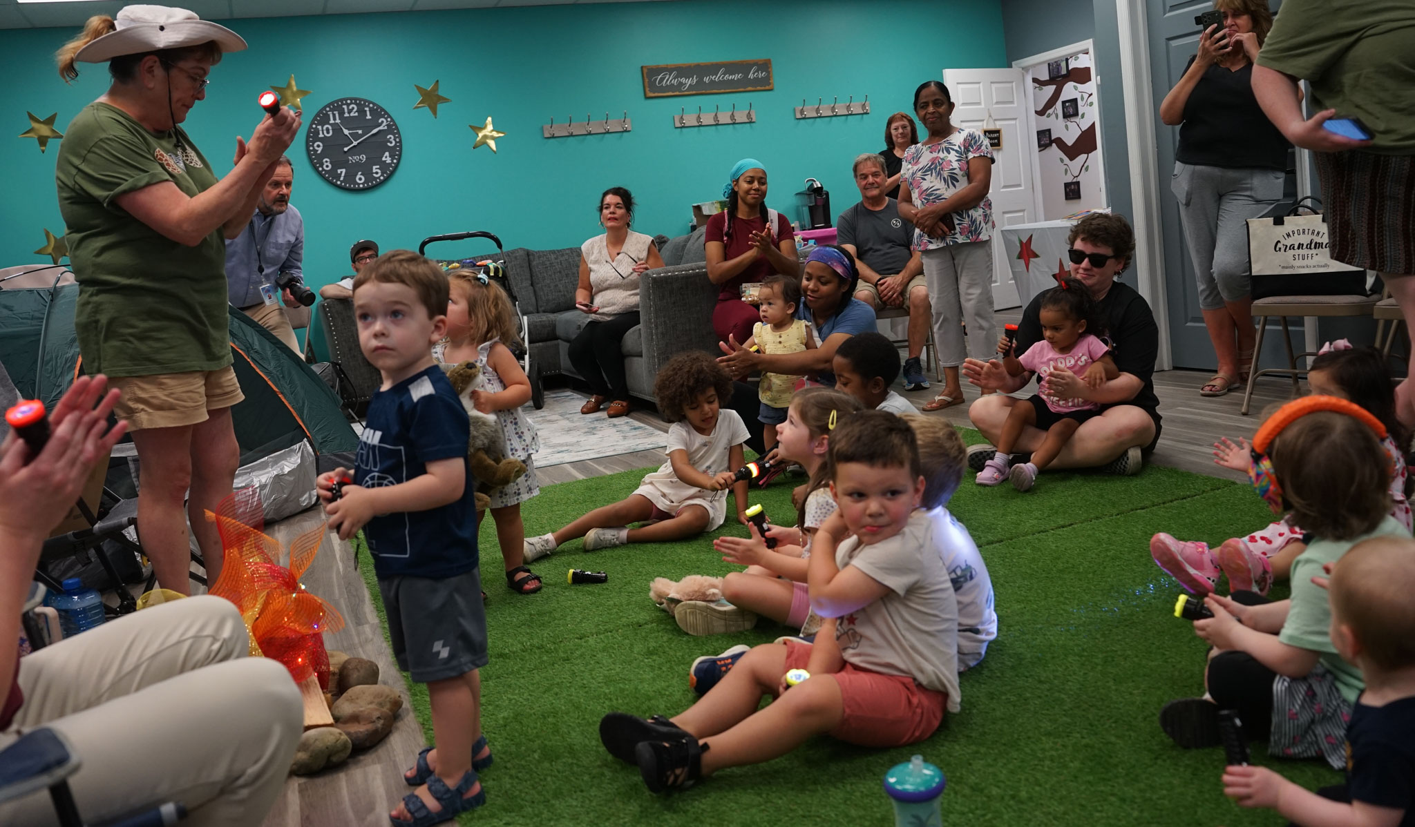 Children gathered around Ms. Robin as she tells a story