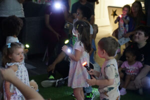Children with flashlights in the dark room "stargazing"