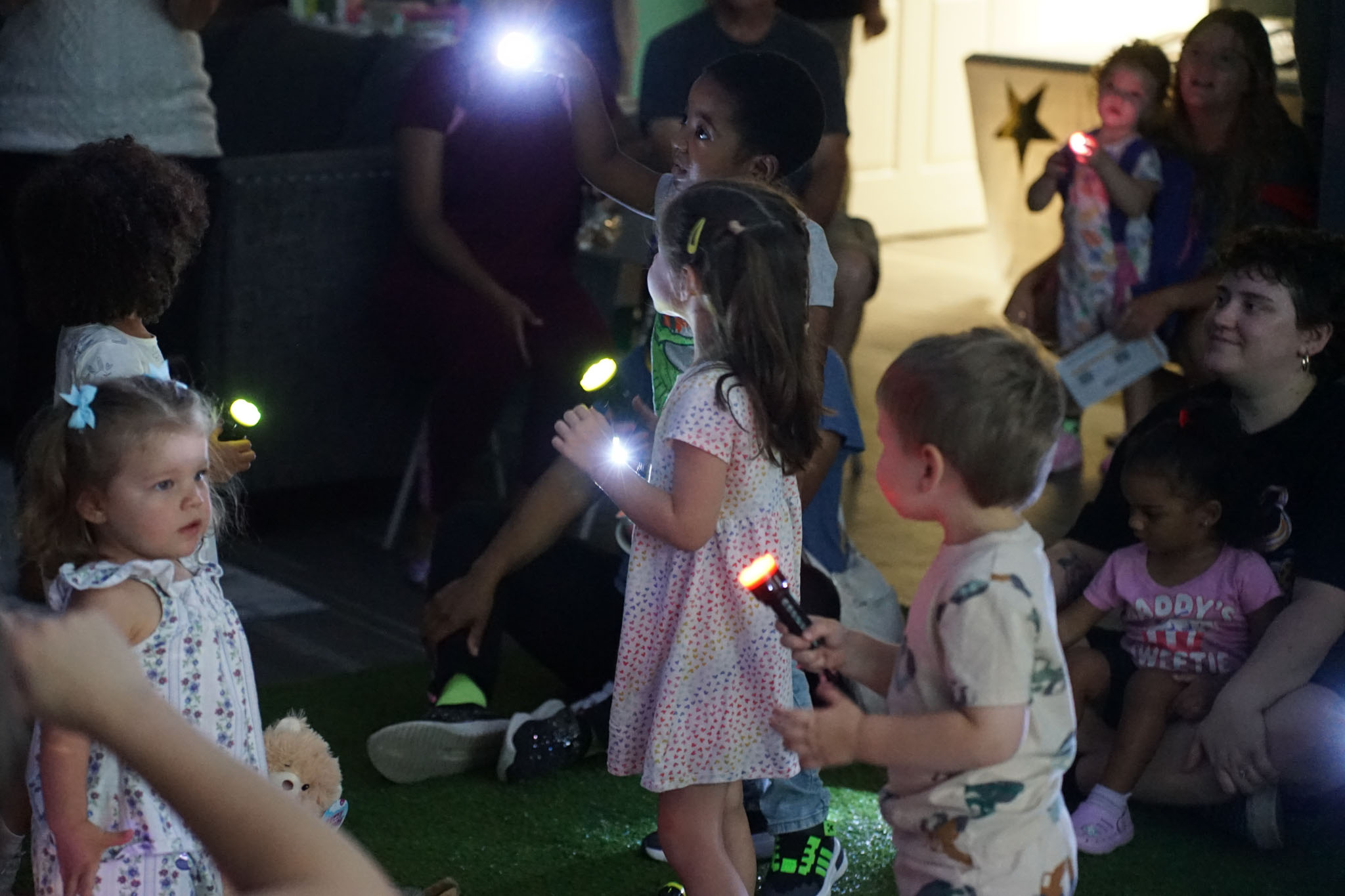 Children with flashlights in the dark room "stargazing"