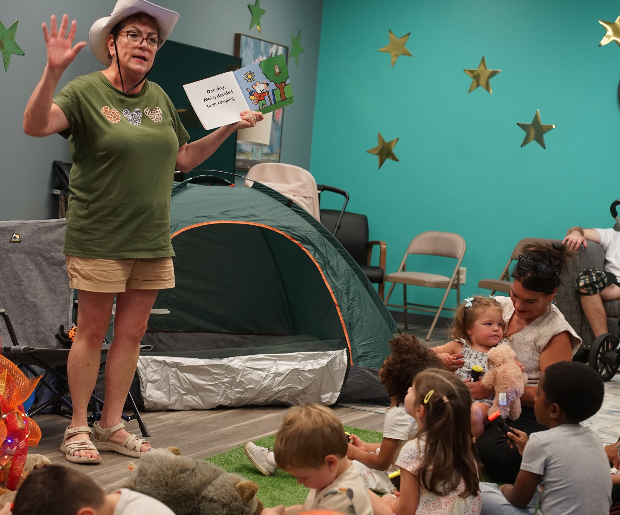 Children gathered around Ms. Robin as she tells a story