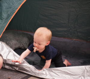 Child crawling out of a camping tent