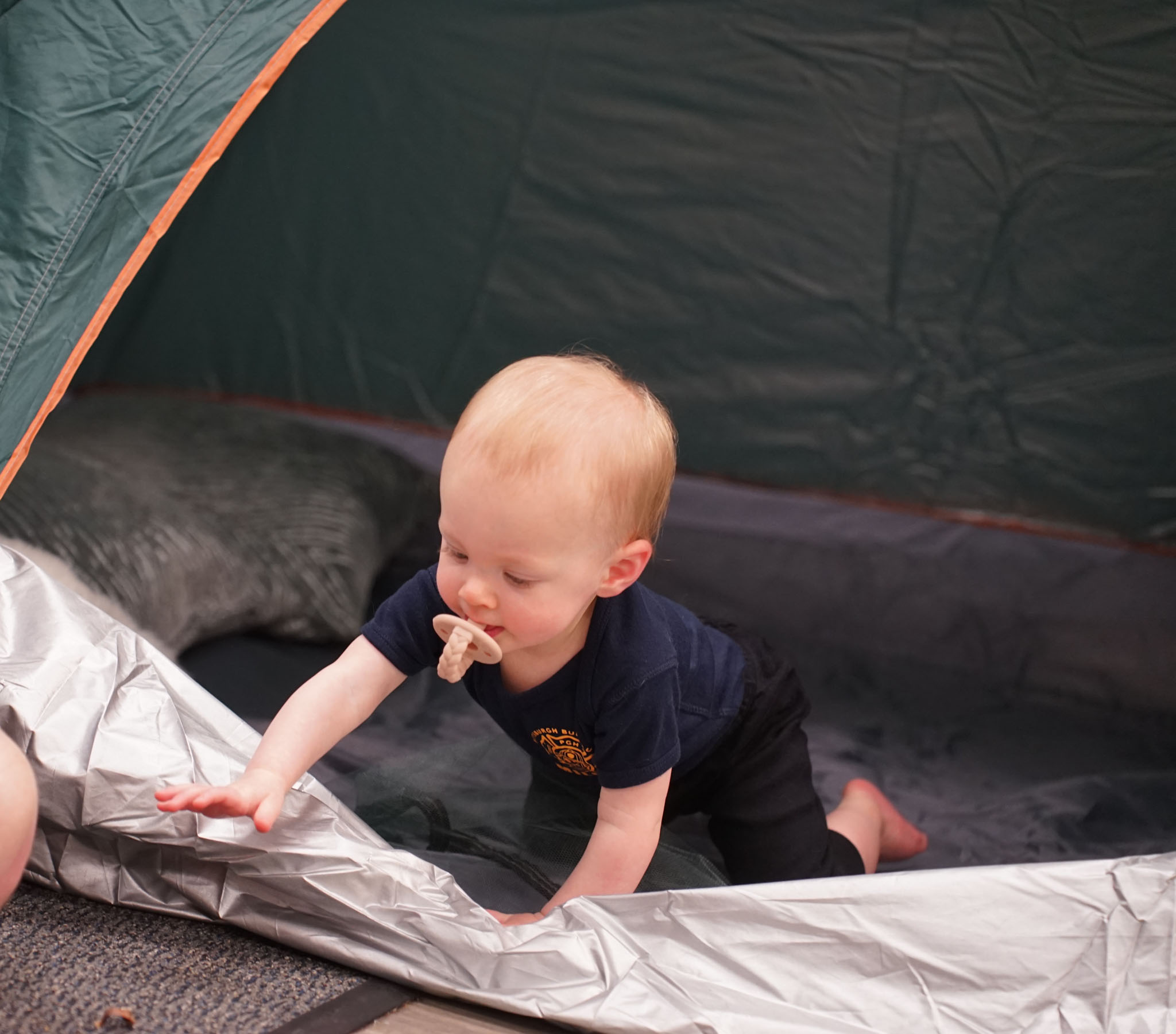 Child crawling out of a camping tent