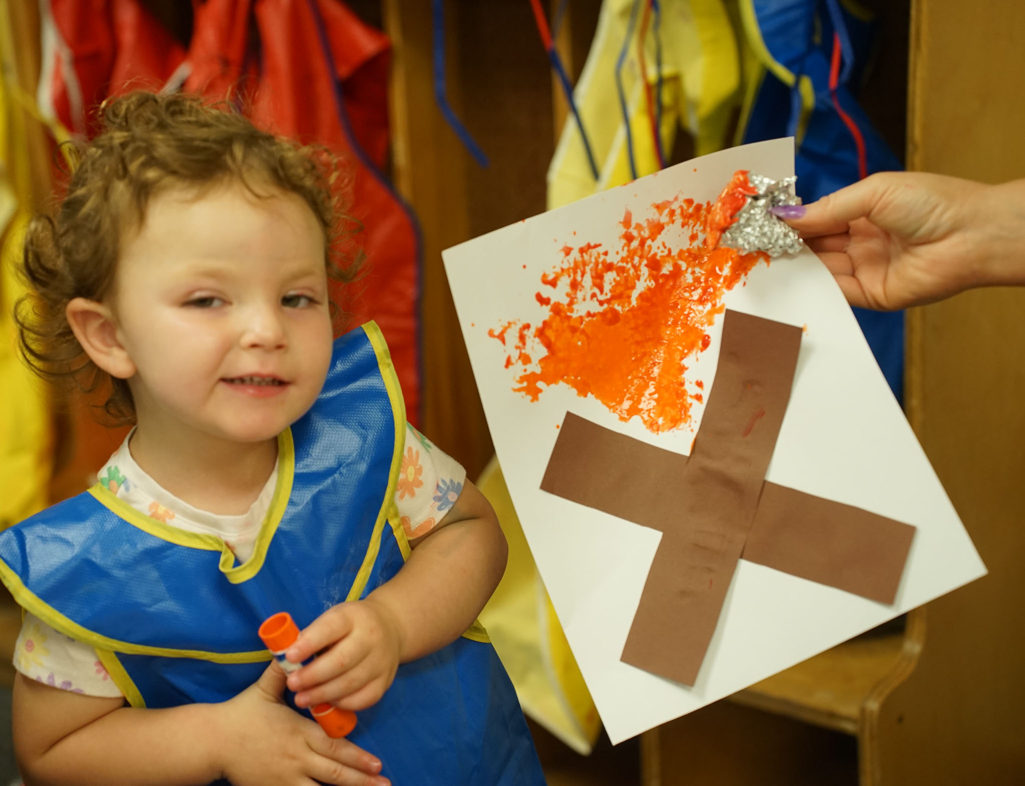 Child posing with a painted campfire craft