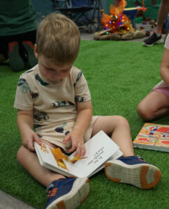 Child reading children's book on playmat