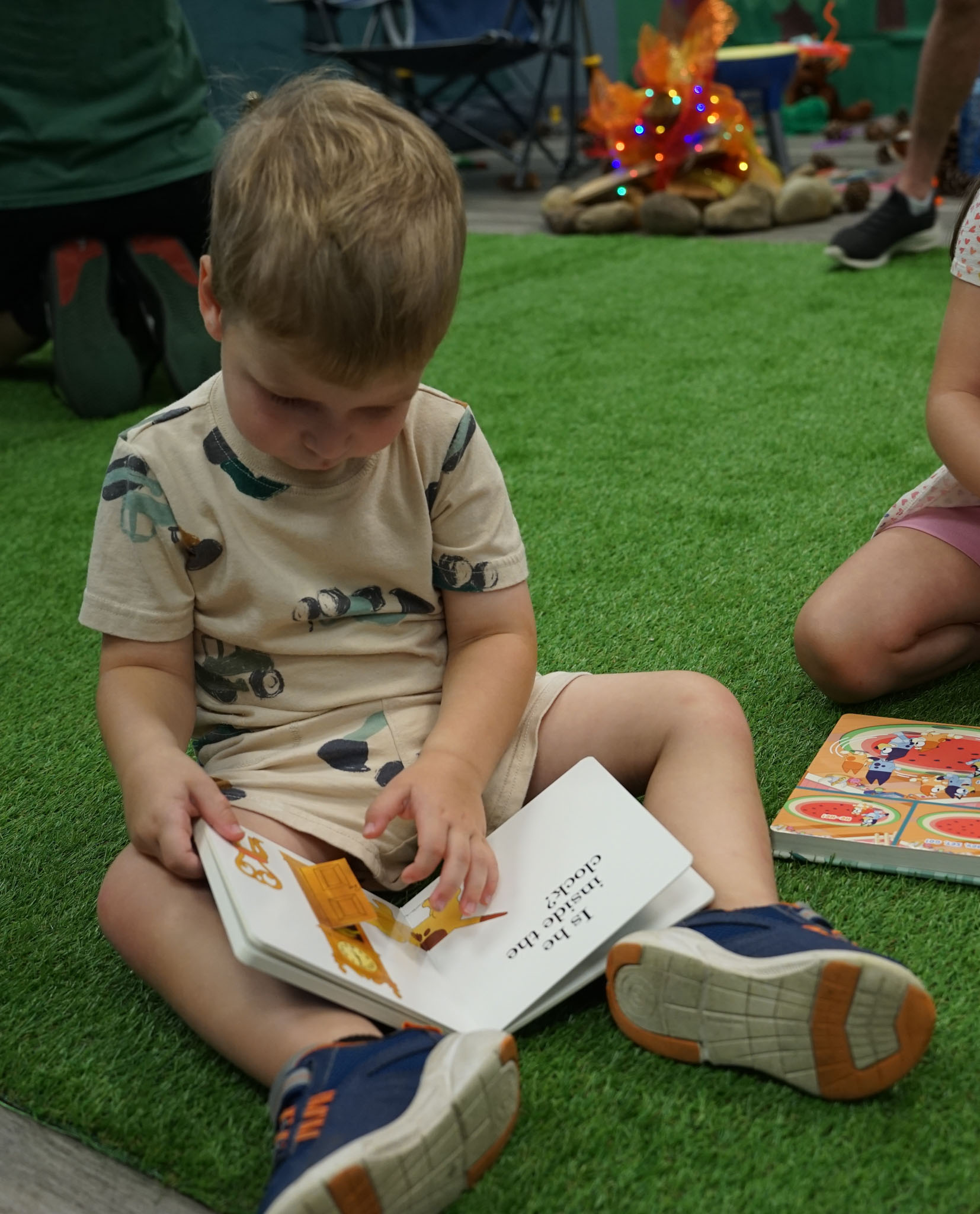 Child reading children's book on playmat