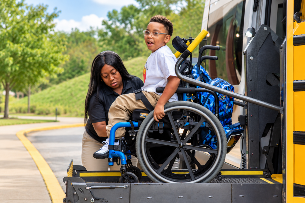 student in wheelchair getting off bus