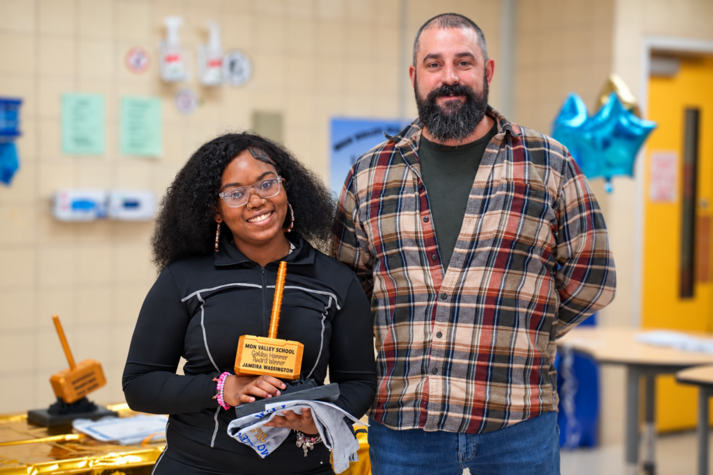 mon-valley-golden-hammer teacher presents student with golden hammer award