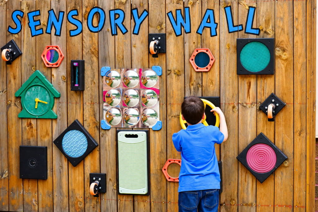student interacting with sensory wall
