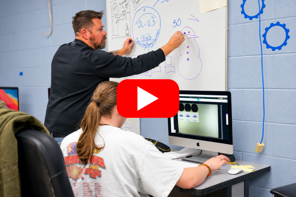 teacher working with student on computer