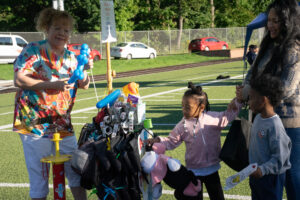 A vendor makes balloon animals for kids