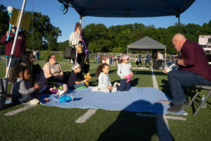 Guest reader reading to an audience of kids