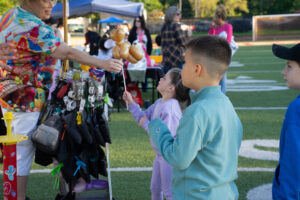 A vendor makes balloon animals for kids