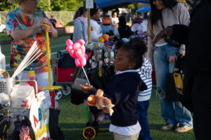 A vendor makes balloon animals for kids